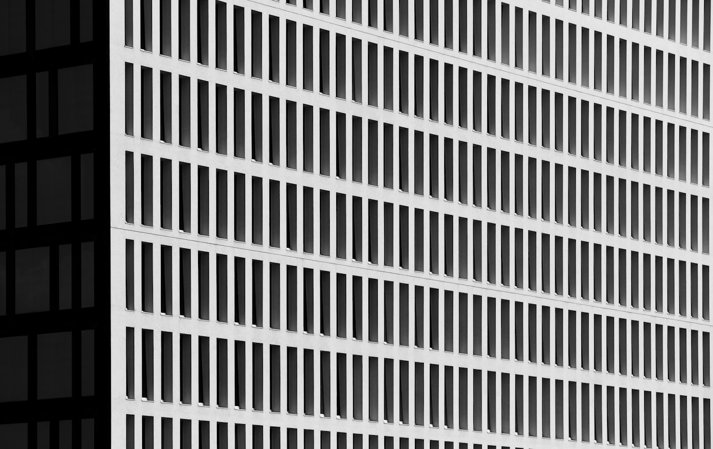 Moderne Gebäudefassade mit einem Raster rechteckiger Fenster.