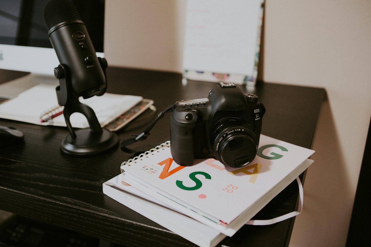 Modernes kreatives Büro mit Mikrofon, Notizbuch und Kamera.