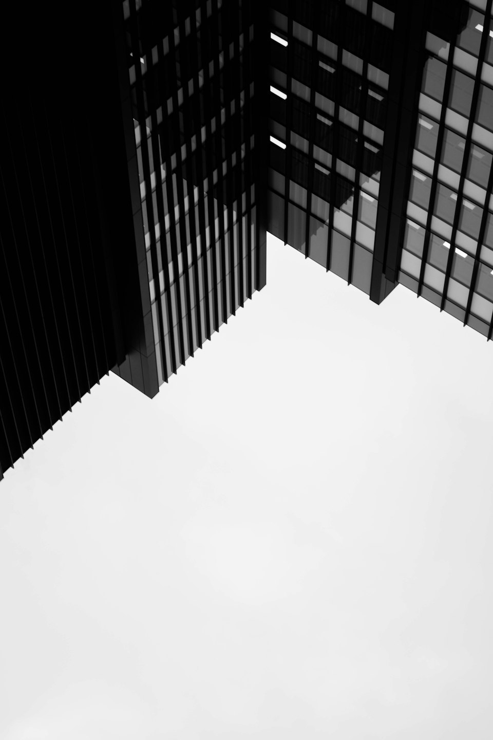 Zwei moderne Gebäude, die sich vor einem hellen Himmel treffen.